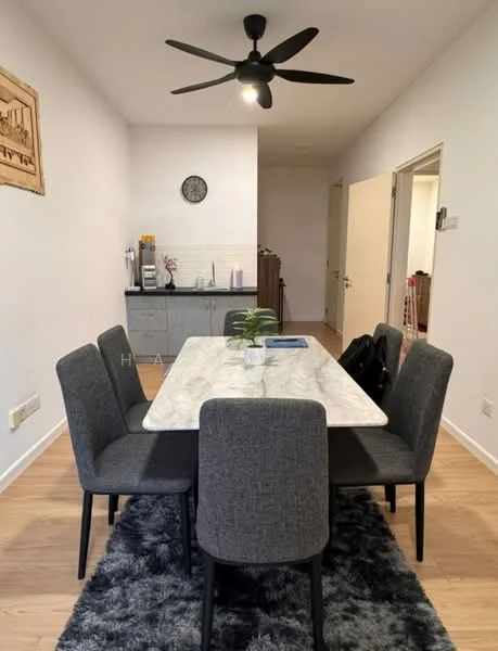 Dining features: marble dining table, 6 upholstered dining chairs in grey, area rug with shaggy texture, 5-blade ceiling fan in black, wall-mounted clock, kitchenette in background with grey cabinetry, countertop appliances visible, light wood flooring; style: modern.