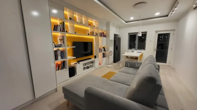Living features: grey fabric sectional sofa, white entertainment unit, built-in shelving with warm LED lighting, wall-mounted TV, light wood flooring, recessed ceiling lights, dining table with chairs, large windows with black frames, white walls, open layout to kitchen, decorative area rug in yellow, kitchen island with seating; style: modern.