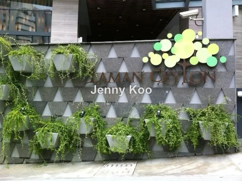 Exterior features: decorative wall with geometric pattern, greenery in hanging planters, signage with the name 'Taman Ceylon', grey stone facade, modern architectural elements; style: modern.