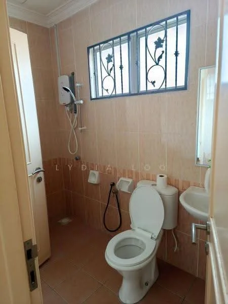 Bathroom features: cream tiled walls, brown tiled flooring, one-piece toilet, shower with wall-mounted faucet, mirror above sink, sink with chrome faucet, window with security bars, handheld shower, toilet paper holder.