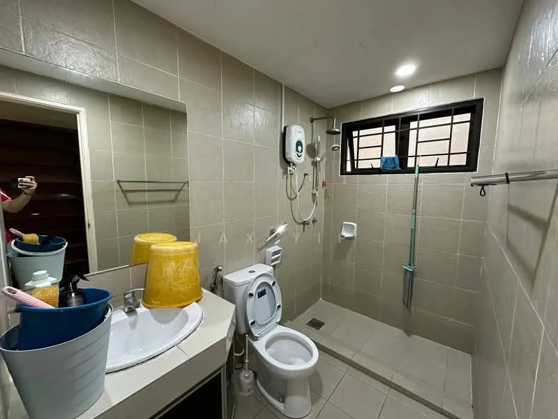 Bathroom features: cream tiled walls, light grey tiled flooring, single-sink vanity with countertop, chrome basin mixer faucet, framed mirror, one-piece toilet, handheld shower, shower area with glass partition, wall-mounted water heater, towel rack, window with black grille, storage basket, cleaning supplies in containers; style: modern.