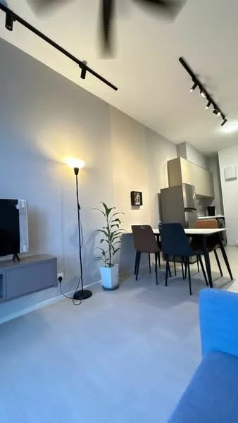 Living features: light grey painted walls, laminate flooring, 5-blade ceiling fan, floor lamp, TV console, wall-mounted TV, plant in white pot, dining table with chairs, kitchen area visible in background, refrigerator visible in background, track lighting; style: modern.