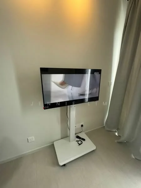 Room features: wall-mounted TV, white wall, light-colored flooring, curtains, TV stand on wheels, power outlet visible.