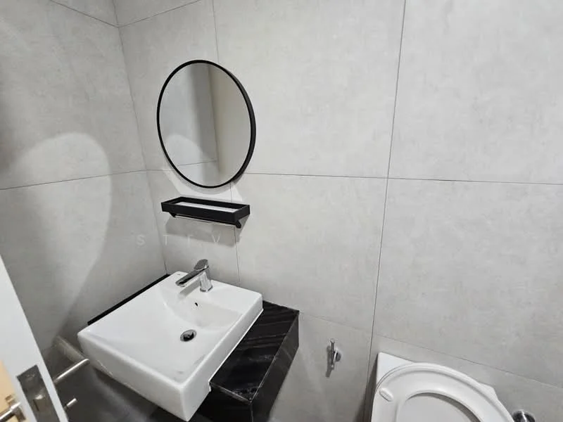 Bathroom features: wall-mounted sink, black marble countertop, chrome faucet, round mirror with black frame, grey tiled walls, white toilet, minimalist design, shelf above sink; style: modern.