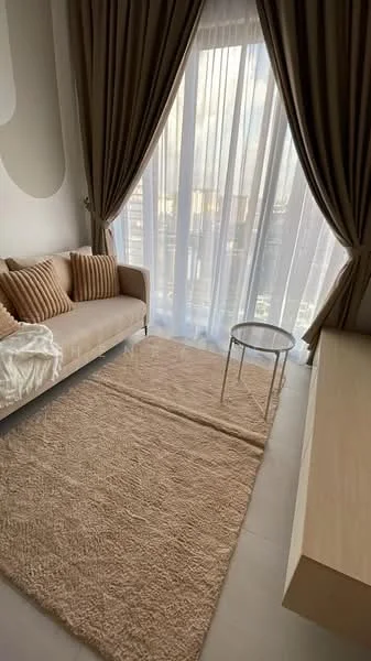 Living features: beige fabric sofa, decorative cushions in striped pattern, round glass side table, area rug in light beige, floor-to-ceiling windows, sheer curtains, wooden console table, neutral wall color; style: modern; view: city.
