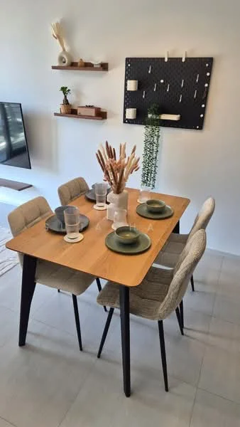Dining features: wooden dining table with light brown finish, 4 upholstered dining chairs in light grey, set of 4 green plates, set of 4 clear drinking glasses, decorative vase with dried flowers, wall-mounted shelf with decorative items, neutral wall color, tile flooring in light grey; style: modern.