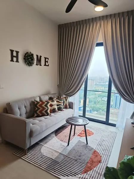 Living features: 3-seater fabric sofa in light grey, decorative cushions with geometric patterns, round coffee table, area rug with circular patterns, floor-to-ceiling windows, sheer curtains, dark curtain drapes, wall-mounted decorative letters spelling 'HOME', indoor plant, ceiling fan; style: modern; view: city.