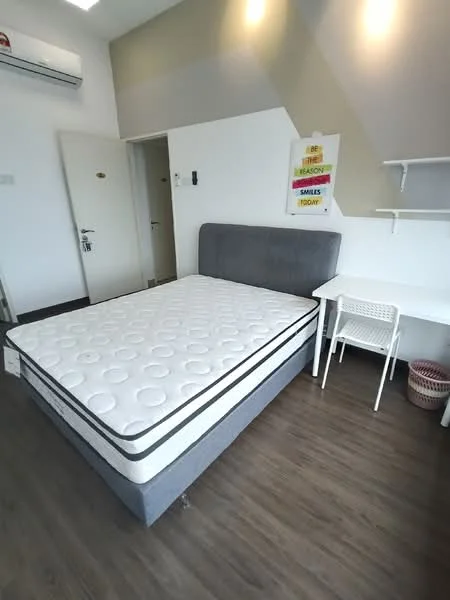 Bedroom features: queen-size bed with grey upholstered headboard, white bedding with circular pattern, wood laminate flooring, white walls, air conditioning unit on wall, desk with white frame and chair, shelf unit on wall, door leading to hallway, decorative wall art, wastebasket; style: modern.
