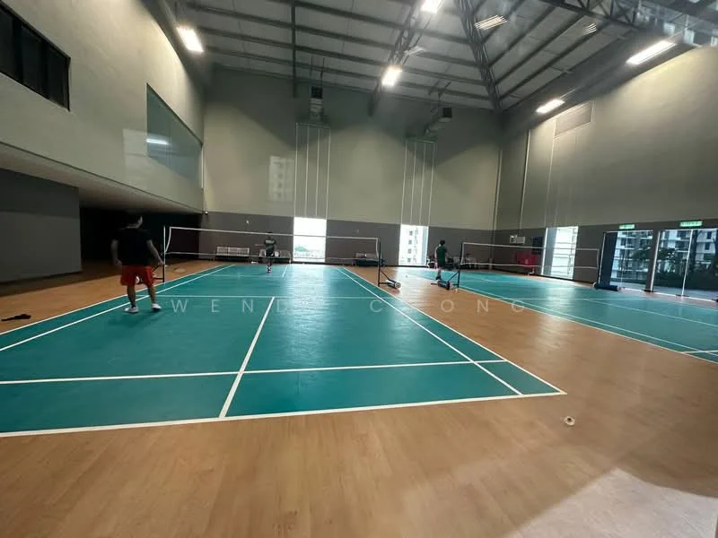 Exterior type: clubhouse; features: indoor badminton courts, high ceilings, wooden flooring, large windows, green walls, court markings, sports equipment, lighting fixtures; style: modern.