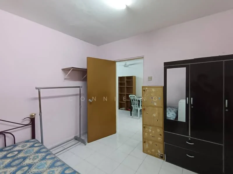 Room features: pink painted walls, white tiled flooring, single bed with patterned bedding, metal bed frame, wardrobe with mirrored doors, wooden chest of drawers, open shelving unit, plastic chair, door leading to another room.