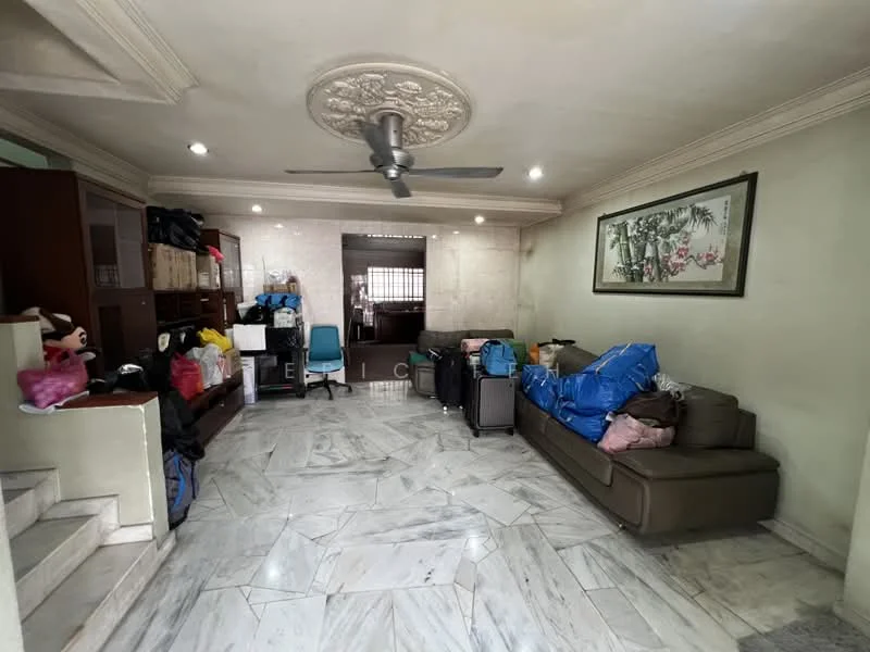 Living features: marble flooring, cream painted walls, exposed ceiling with decorative plaster, 5-blade ceiling fan, sofa in brown fabric, wooden cabinet, decorative wall art, various bags and luggage, natural light from window, open layout to adjacent space; style: traditional.