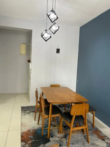 Dining features: wooden dining table, 4 wooden dining chairs, pendant lighting with three fixtures, area rug with abstract pattern, white painted walls, blue accent wall, tile flooring; style: modern.