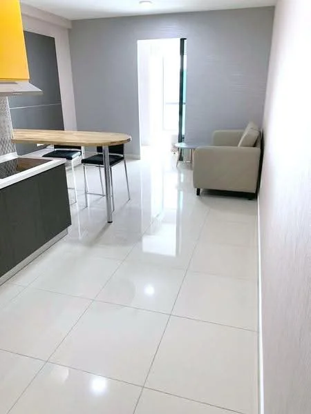 Kitchen features: white glossy tile flooring, grey painted walls, yellow cabinetry, wooden countertop, stainless-steel appliances, bar stools, open layout, recessed ceiling lights; style: modern. Living features: beige fabric sofa, minimalist design, natural light from window, white walls; style: modern.