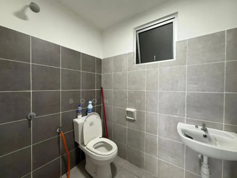Bathroom features: grey tiled walls, white toilet, single-sink vanity with chrome faucet, small window, shower head, grey tiled flooring, toilet paper holder, cleaning supplies on the wall.