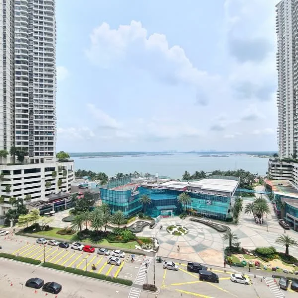 Exterior type: high-rise condominium; features: glass curtain wall, surrounded by palm trees, manicured landscaping, waterfront view, multiple high-rise buildings, open-air parking lot, modern architecture, city skyline in background; style: modern.