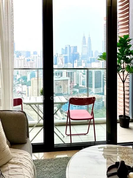 Living features: floor-to-ceiling windows, sliding glass door, city skyline view, sofa in light grey fabric, coffee table, area rug with geometric pattern, decorative plant in pot, red chair, outdoor dining table, curtains, wall-mounted decor; style: modern; view: city.