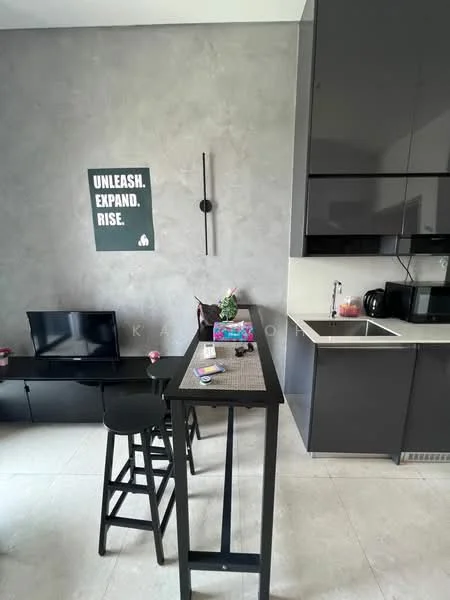 Kitchen features: grey accent wall, black cabinetry, white countertop, single-bowl stainless-steel sink, chrome pull-down faucet, built-in oven, black microwave, black kettle, stool seating, decorative wall art, flat-screen TV, tile flooring; style: modern.