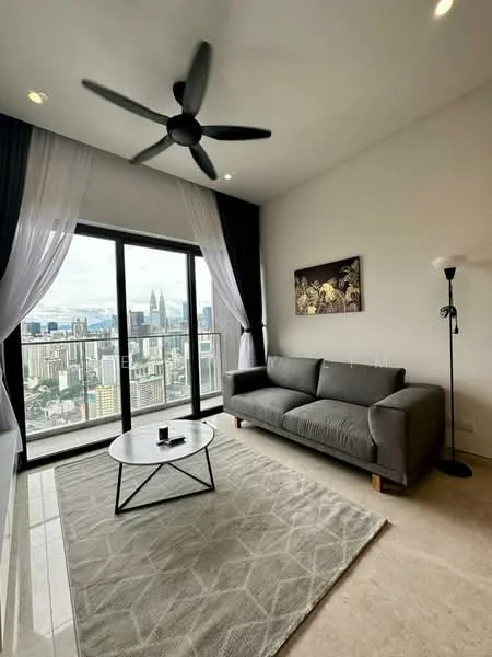 Living features: 3-seater fabric sofa in grey, round coffee table with black metal base, area rug with geometric pattern, floor-to-ceiling windows, sheer curtains, blackout curtains, 5-blade ceiling fan with light, wall-mounted lamp, framed artwork on wall, city skyline view; style: modern; view: city.