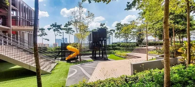 Exterior type: landscape garden; features: playground with slide, play structure, manicured lawn, mature trees, wooden decking, landscaped garden beds, walking paths, outdoor seating area, city skyline in background, open green space; style: modern.