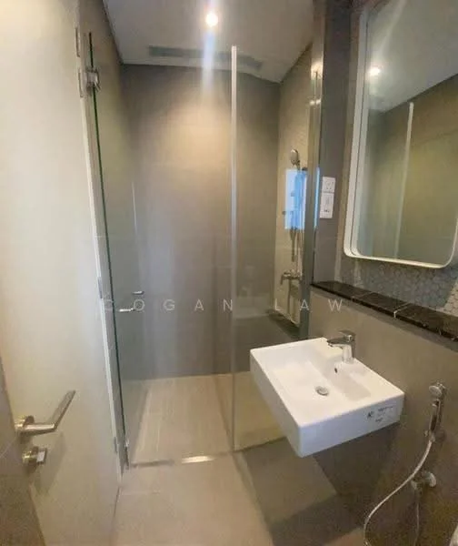 Bathroom features: walk-in shower with glass enclosure, chrome handheld shower, wall-mounted faucet, white wall-mounted sink, mirror with rounded edges, grey tiled walls, light grey floor tiles, recessed downlights; style: modern.