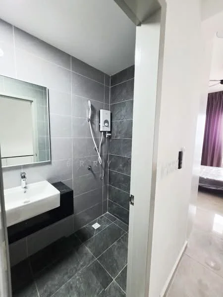 Bathroom features: grey tiled walls, grey tiled flooring, single-sink vanity with black cabinet, mirror above sink, shower area with glass partition, wall-mounted shower head, water heater unit, chrome basin mixer faucet; style: modern. Room features: light-colored walls, doorway leading to another room, visible flooring from adjacent room.