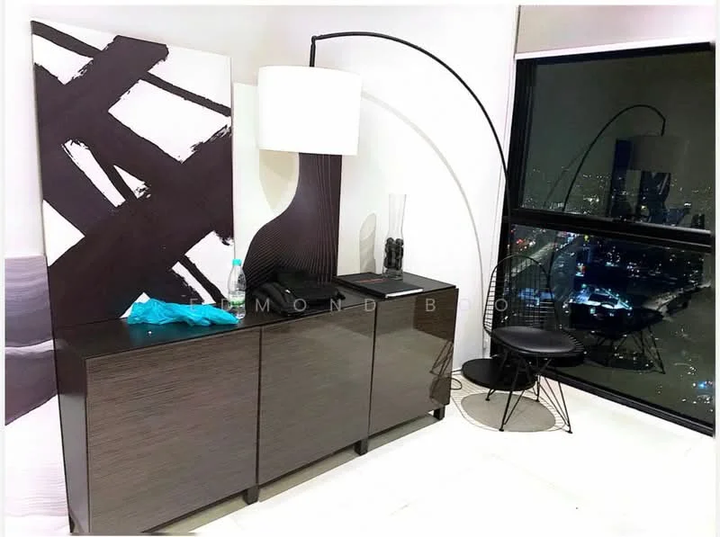 Room features: dark wood console table, abstract wall art with black and white design, floor lamp with curved arm, black accent chair, decorative vase, bottle of water, city skyline view through large window, white tiled flooring; style: modern; view: city.
