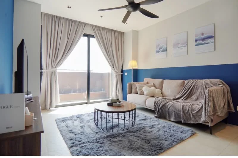Living features: 3-seater fabric sofa in beige, decorative throw blanket, round coffee table with metal base, area rug with geometric pattern, floor-to-ceiling windows, sheer curtains, wall-mounted TV, light fixture, ceiling fan with light, framed artwork on walls; style: modern.
