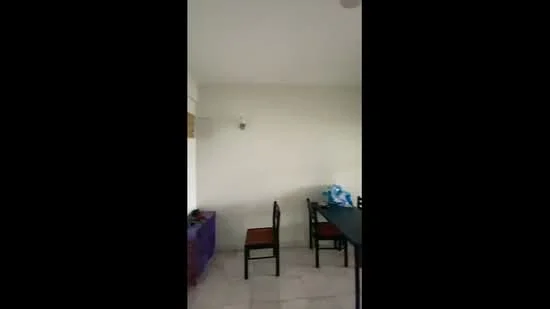 Room features: white painted walls, tile flooring, 4 wooden chairs, 1 black table, light fixture on ceiling.