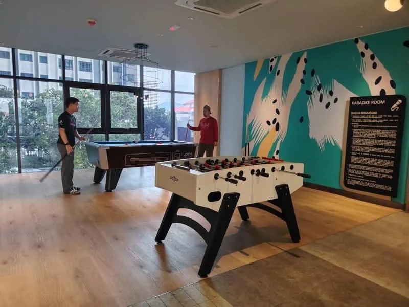 Room features: wooden flooring, large windows, wall-mounted air conditioning unit, colorful wall mural, pool table, foosball table, seating area, decorative wall signage; style: modern; view: garden.