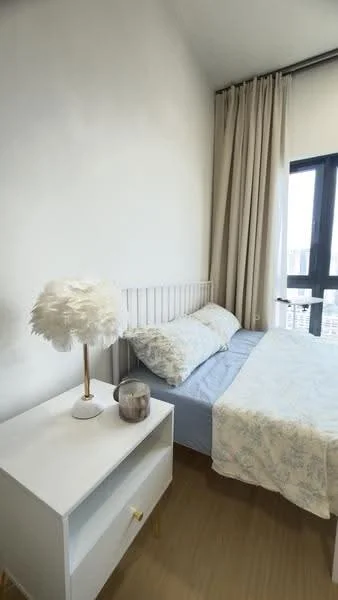 Bedroom features: queen-size bed with light blue bedding, white bed frame, white nightstand with a drawer, table lamp with a feather shade, floor-to-ceiling window, light-colored curtains, wooden flooring, decorative throw blanket; style: modern; view: city.