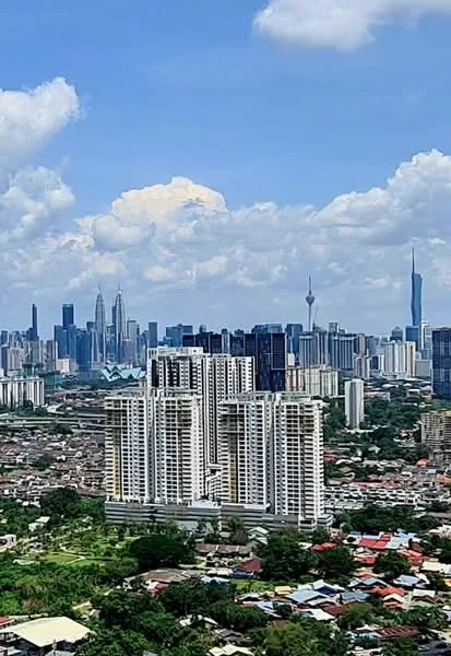 Exterior type: high-rise condominium; features: city skyline view, multiple high-rise buildings, green landscape in foreground, urban residential area, clear blue sky, clouds in the sky; style: modern.