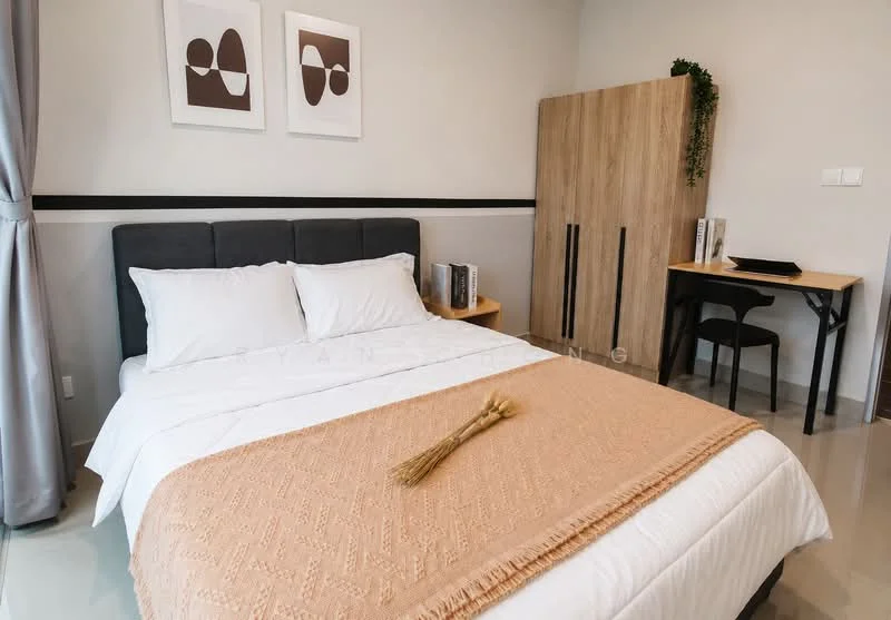 Bedroom features: king-size bed with white bedding, upholstered headboard in grey, decorative throw blanket in beige, two framed artworks on the wall, wooden wardrobe with two doors, small study desk with black chair, flooring in polished concrete, curtains in light grey, wall with black accent stripe; style: modern.