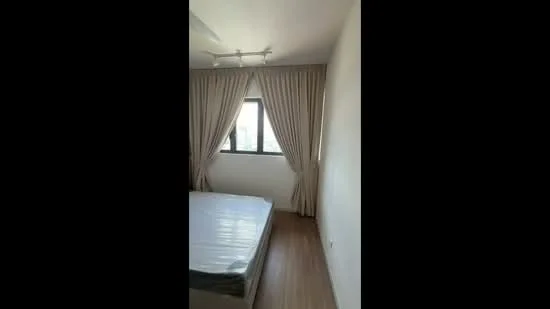 Bedroom features: queen-size bed, 5-blade ceiling fan with light, floor-to-ceiling window, sheer curtains, wooden flooring, white painted walls, decorative wall, natural light from window; style: modern; view: city.