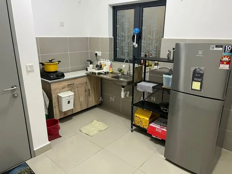 Kitchen features: grey tiled walls, white painted walls, light grey floor tiles, single-bowl stainless-steel sink, chrome pull-down faucet, wood cabinetry with light finish, freestanding stainless-steel fridge, black metal shelving unit, stainless-steel cooking pot on stove, microwave on shelf, kitchen utensils on countertop, red plastic bucket, dish drying rack, white dish towel on floor; style: modern.