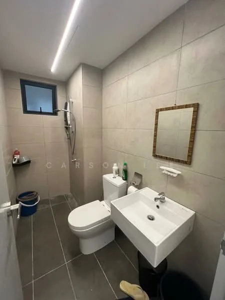 Bathroom features: grey tiled walls, light grey floor tiles, wall-mounted sink, single-basin sink, chrome faucet, toilet, shower area with handheld shower, mirror with wooden frame, small shelf, window, waste bin; style: modern.