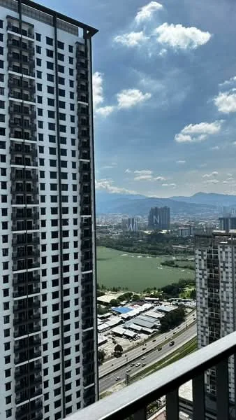 Exterior type: high-rise condominium; features: glass curtain wall, balconies on upper floors, surrounding city skyline, view of water body, urban landscape, highway visible below, mountains in the background; style: modern.