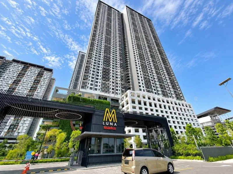 Exterior type: high-rise condominium; features: glass curtain wall, greenery on facade, recessed balconies, feature signage at entrance, manicured landscaping, paved driveway, parking area, modern architectural design; style: modern.