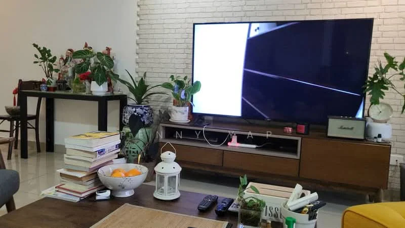 Living features: white painted walls, exposed brick accent wall, glossy tile flooring, large flat-screen TV, wooden TV console, decorative plants, coffee table, stack of books, lantern, fruit bowl with oranges, side table with clock, remote control; style: modern.