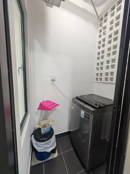 Laundry features: front-load washing machine in silver, black countertop, white painted walls, black tile flooring, window with white frame, plastic laundry basket, pink folding table, exposed brick wall, power outlet.