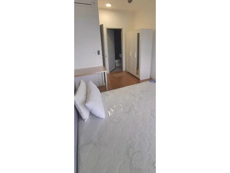 Bedroom features: queen-size bed, wooden flooring, built-in wardrobe, table, white walls, recessed ceiling lights, air conditioning unit, doorway leading to bathroom; style: modern.
