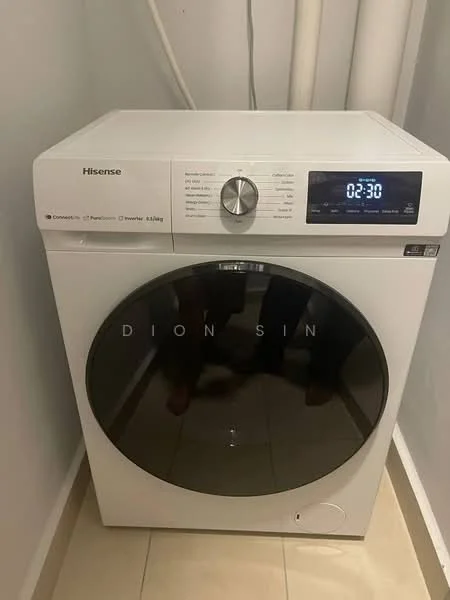 Laundry features: front-load washing machine, white appliance, digital display, control panel with knobs, chrome door handle, tile flooring, plumbing pipes visible, neutral wall color.