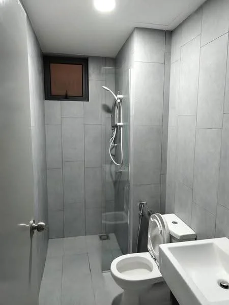 Bathroom features: grey tile cladding on walls, grey tile flooring, walk-in shower with glass enclosure, rain shower head, handheld shower, chrome basin mixer faucet, white toilet, bidet spray, single-sink vanity with white cabinet, small window for natural light, recessed ceiling lights; style: modern.
