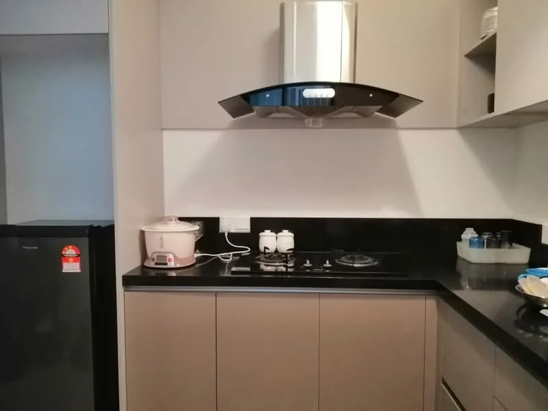Kitchen features: black granite countertop, grey cabinetry, stainless-steel range hood, 4-burner gas hob, white rice cooker, black fridge, white ceramic canisters, glass water bottles, kitchen utensils, wall-mounted shelves; style: modern.