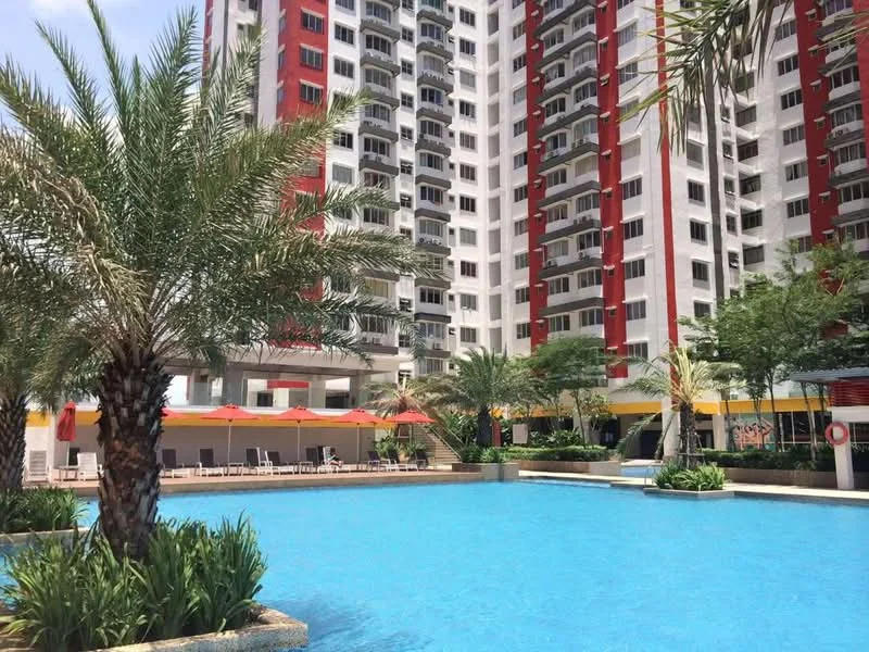 Exterior type: high-rise condominium; features: swimming pool, pool deck with loungers, palm trees, manicured landscaping, red and white facade, multiple storeys, outdoor seating area with umbrellas; style: modern.