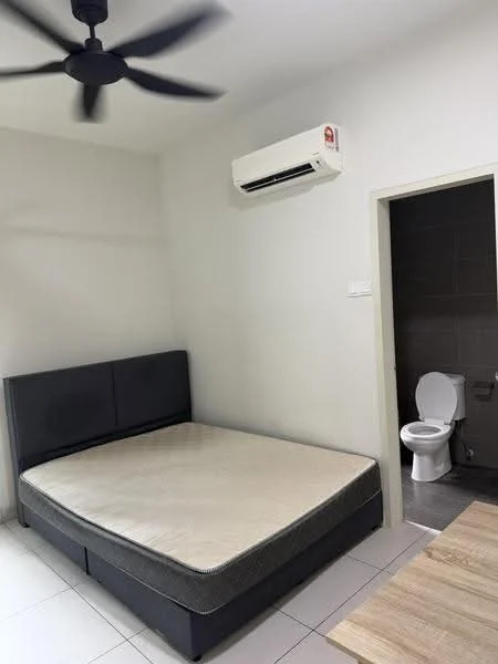 Bedroom features: queen-size bed base without mattress, 5-blade ceiling fan, wall-mounted split AC, light grey painted walls, white tiled flooring, doorway leading to bathroom, neutral colour scheme; style: modern. Bathroom features: one-piece toilet, grey tiled walls, grey tiled flooring, door leading to bedroom.
