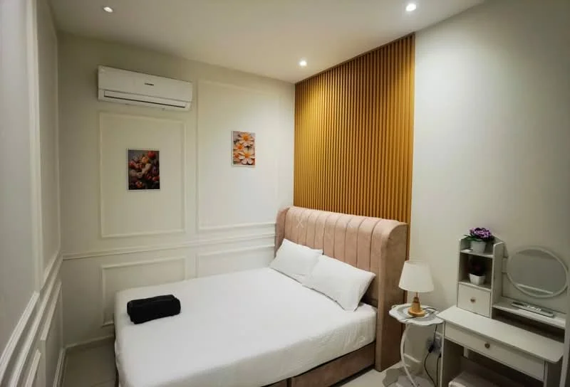 Bedroom features: queen-size bed with upholstered headboard in light pink, white bedding, 2 bedside lamps, wall-mounted air conditioning unit, decorative artwork on walls, wood panel accent wall, white painted walls with crown moulding, nightstand with drawer, mirror on nightstand, flooring in light tiles; style: modern.