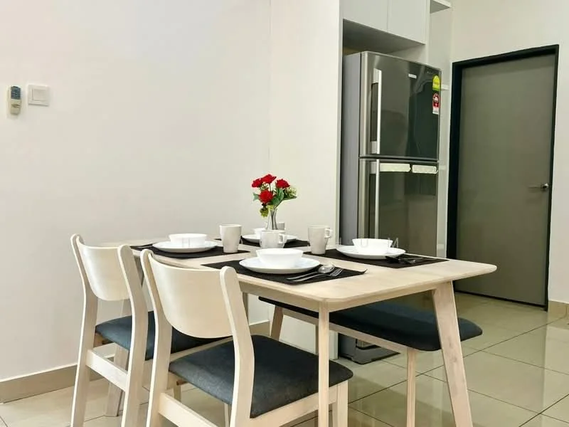 Dining features: 4-seater dining table, light wood table, grey upholstered dining chairs, white ceramic plates, cutlery, small vase with red flowers, tile flooring, white painted walls, refrigerator, doorway to another room; style: modern.