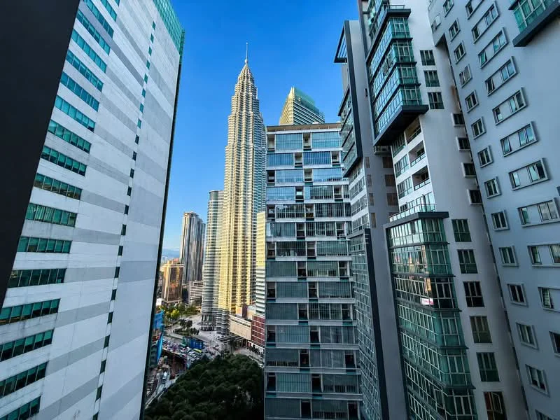 Exterior type: high-rise condominium; features: glass curtain wall, recessed balconies, approximately 50-storey high-rise, surrounded by mature greenery, city skyline view, modern architectural design; style: contemporary.