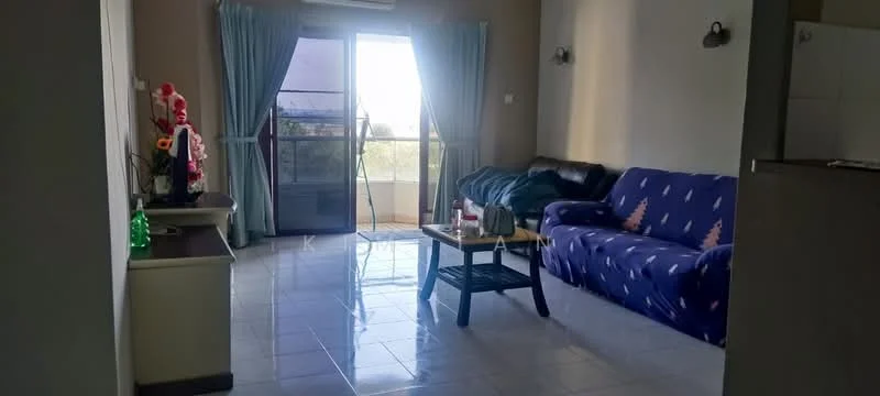 Living features: blue fabric sofa with patterned design, black leather sofa, glass coffee table, white painted walls, tile flooring, floor-to-ceiling windows, curtains, air conditioning unit, decorative plants, wall-mounted light fixtures; style: modern; view: city.