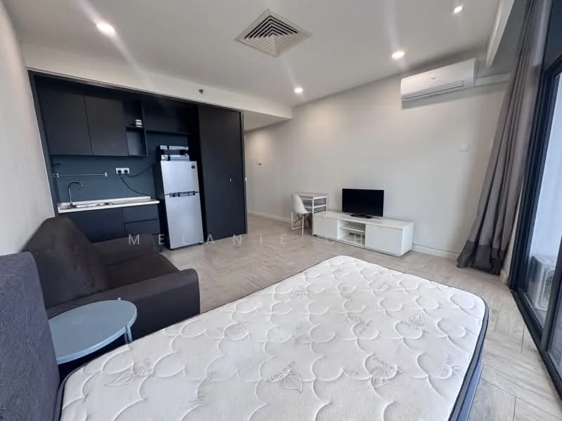 Living features: grey fabric sofa, white TV console, wall-mounted TV, small round side table, refrigerator, built-in kitchen cabinetry, recessed downlights, air conditioning unit, large window with sheer curtains, wood-look tile flooring, queen-size mattress on bed frame; style: modern.